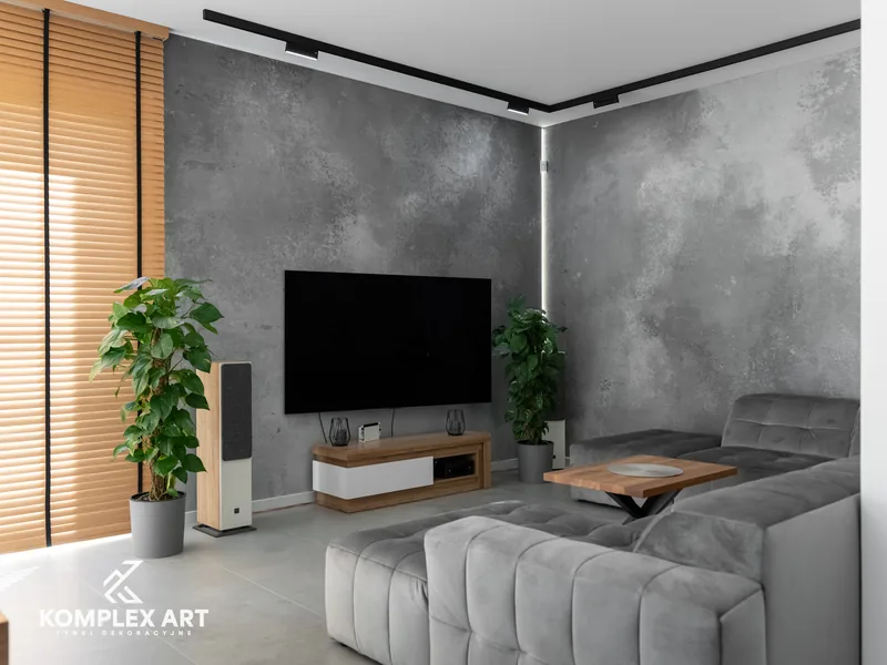 Salon z szarą ścianą w efekcie wabi-sabi za strefą telewizyjną, realizacja Komplex Art